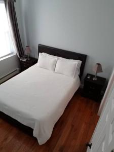 a bedroom with a large white bed with two night stands at Wonderful & Cozy Apartment Close to Time Square NYC in North Bergen