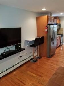 a kitchen with a table and a television and a refrigerator at Wonderful & Cozy Apartment Close to Time Square NYC in North Bergen
