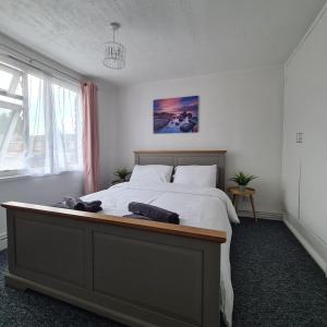 a bedroom with a large bed with white sheets at Freshen-Up Stays in Oakengates