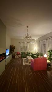 艾卜哈فيلا ممشى الضباب的客厅配有绿色沙发和红色椅子