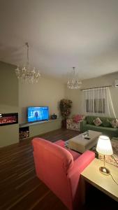 ein Wohnzimmer mit einem roten Sofa und einem Fernseher in der Unterkunft فيلا ممشى الضباب in Abha + 16 Fotos