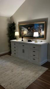 biała komoda z dwoma lampami na górze w obiekcie فيلا ممشى الضباب w mieście Abha