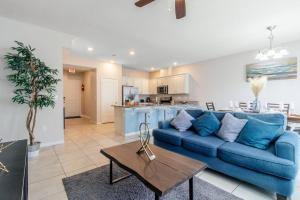 a living room with a blue couch and a kitchen at 5 mins from Disney, Family Friendly Townhome in Kissimmee