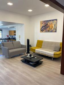 Sala de estar con 2 sofás y mesa de centro en Friendly house en Funchal