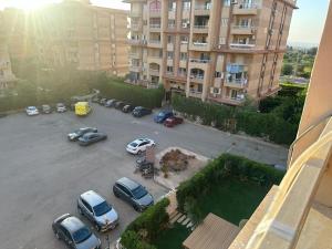 vistas a un aparcamiento con coches y a un edificio en شقة مفروشة بالقاهرة مدينة المستقبل en Madīnat ash Shurūq