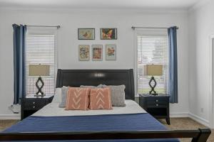 1 dormitorio con 1 cama con 2 mesitas de noche y 2 lámparas en Burnside Beauty 4BR Pingpong Patio en Tallahassee