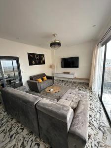 een woonkamer met een bank en een tv bij Appartement neuf/vue sur mer in Yof