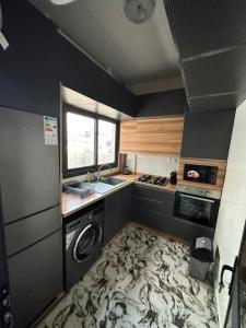 een keuken met een wastafel, een wasmachine en een droger bij Appartement neuf/vue sur mer in Yof