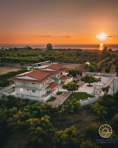 an aerial view of a house with the sunset in the background at Terra Hélios Suites & Studios in Kyparissia