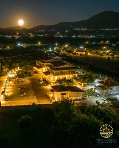 a view of a town at night with the moon at Terra Hélios Suites & Studios in Kyparissia