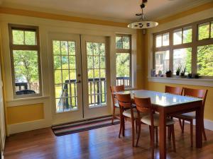 a dining room with a table and chairs and windows at Elegant, Sunny Modern Home with Skylights - Kitsilano, Vancouver in Vancouver