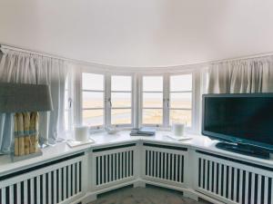 sala de estar con TV de pantalla plana y ventanas en Watthues, en Kampen