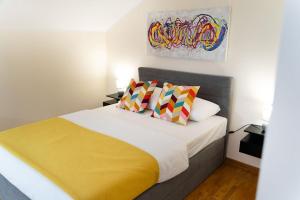 a bedroom with a bed with a yellow blanket at Mini Hotel RiverLux Apartments in Bačka Palanka