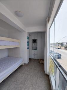 - une chambre avec un lit et une grande fenêtre dans l'établissement Departamento en Punta Hermosa con vista al Mar, à Punta Hermosa