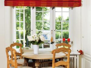 a dining room table with chairs and a vase of flowers at Dorfaue in Kampen