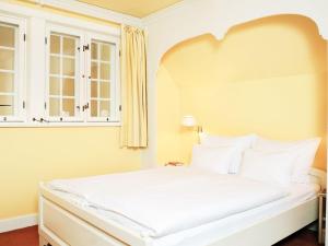 a bedroom with a large white bed with white pillows at Dorfaue in Kampen
