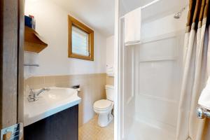 een witte badkamer met een toilet en een wastafel bij King Birch Lake Home, Unit 10 in Alton