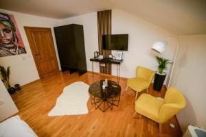 a living room with yellow chairs and a table at Mini Hotel RiverLux Apartments in Bačka Palanka
