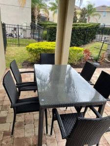 a black table and chairs on a patio at Luxury 6 BR 6 Bath @Encore Resort Pool Spa Grill. in Orlando