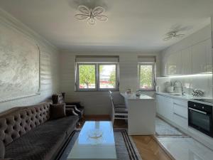 sala de estar con sofá y cocina en ASKonak Apartman Novi Pazar en Novi Pazar