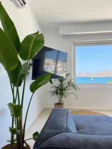 a living room with a blue couch and plants at Elounda Port Apartment in Elounda