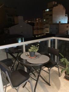 una pequeña mesa y sillas en un balcón por la noche en A&B Apartment en Salta