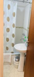 baño con lavabo y cortina de ducha en A&B Apartment en Salta