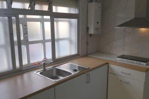 cocina con fregadero y ventana en Casa Ricardo (16km de Coruña), 