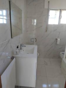 Baño blanco con lavabo y espejo en Casa Ricardo (16km de Coruña), 