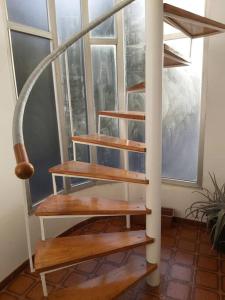 a wooden spiral staircase in a room with a window at Casa Ricardo (16km de Coruña) 