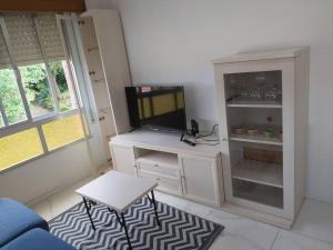 Casa Ricardo (16km de Coruña) : غرفة معيشة مع تلفزيون وخزانة بيضاء