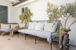 a porch with a bench and potted plants at Inn at Moonlight Beach in Encinitas