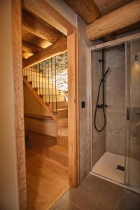a bathroom with a walk in shower next to a staircase at A Barreira -Lar da cima- in Folgoso