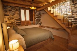 1 dormitorio con 1 cama y escalera en A Barreira -Lar da cima-, en Folgoso