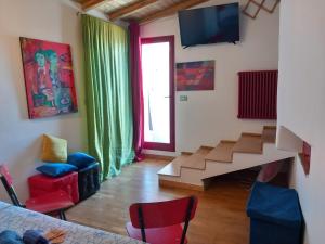 a living room with a tv and a stair case at Terrazza su volta storica in Montesano Salentino