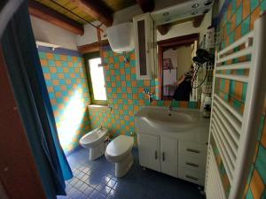 a bathroom with a sink and a toilet and a mirror at Terrazza su volta storica in Montesano Salentino