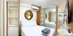 1 dormitorio con cama blanca y baño en Apto Facilties 250m Praia Ponta Verde Luxo, en Maceió