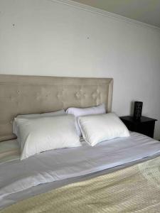 a white bed with two pillows on top of it at Frente al mar, zona exclusiva de Iquique in Iquique