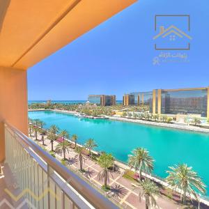 uma vista para uma piscina a partir de uma varanda em بِيُوتات الرفآه - اطلالة بحرية ساحرة em King Abdullah Economic City