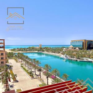 a view of a pool with palm trees and the ocean at بِيُوتات الرفآه - اطلالة بحرية ساحرة in King Abdullah Economic City