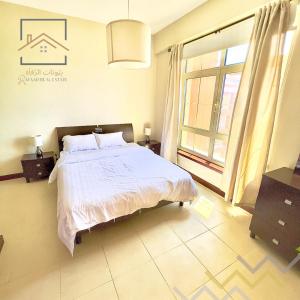 a bedroom with a bed and a large window at بِيُوتات الرفآه - اطلالة بحرية ساحرة in King Abdullah Economic City