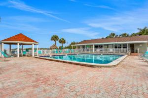 a swimming pool with chairs and a house at Bermuda Bay Beach & Racquet Club, Unit E in St Petersburg