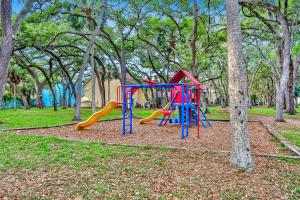 un parque infantil con tobogán en un parque con árboles en Bermuda Bay Beach & Racquet Club, Unit E, en San Petersburgo