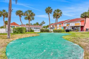 a golf course with palm trees and a building at Bermuda Bay Beach & Racquet Club, Unit E in St Petersburg