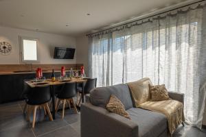 uma sala de estar com um sofá e uma mesa com cadeiras em Escapade Mauriennaise em Saint Avre la Chambre