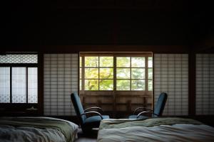 Habitación con 2 camas, sillas y ventana en 草木ももとせ 