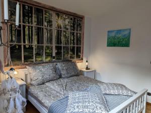 a bedroom with a bed and a large window at Herzstuecke-Ferienwohnung in Ingenried