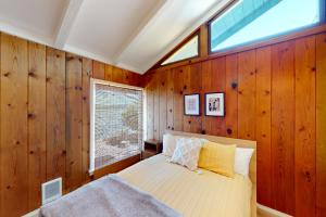 a bedroom with wooden walls and a bed with a window at Euphoria on the Fjord in Hoodsport