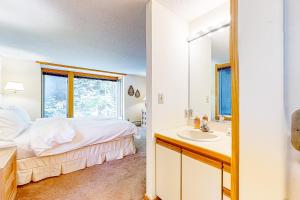 a bedroom with a bed and a sink and a mirror at Mountain Haven Retreat in Stratton Acres