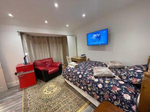 sypialnia z 2 łóżkami i czerwonym krzesłem w obiekcie Luxury Rooms with En-suite bathrooms - West London w mieście Harrow on the Hill